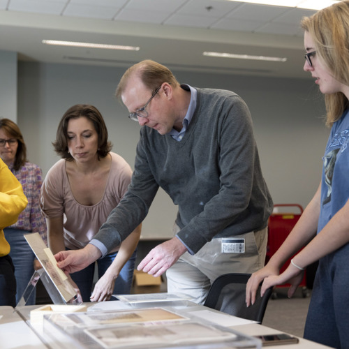 Photograph, UGA students looking at medieval manuscripts during a Hargrett Hours class session.